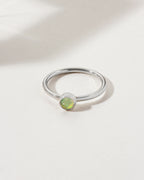 Sterling silver ring with a round, light-green opal gemstone.