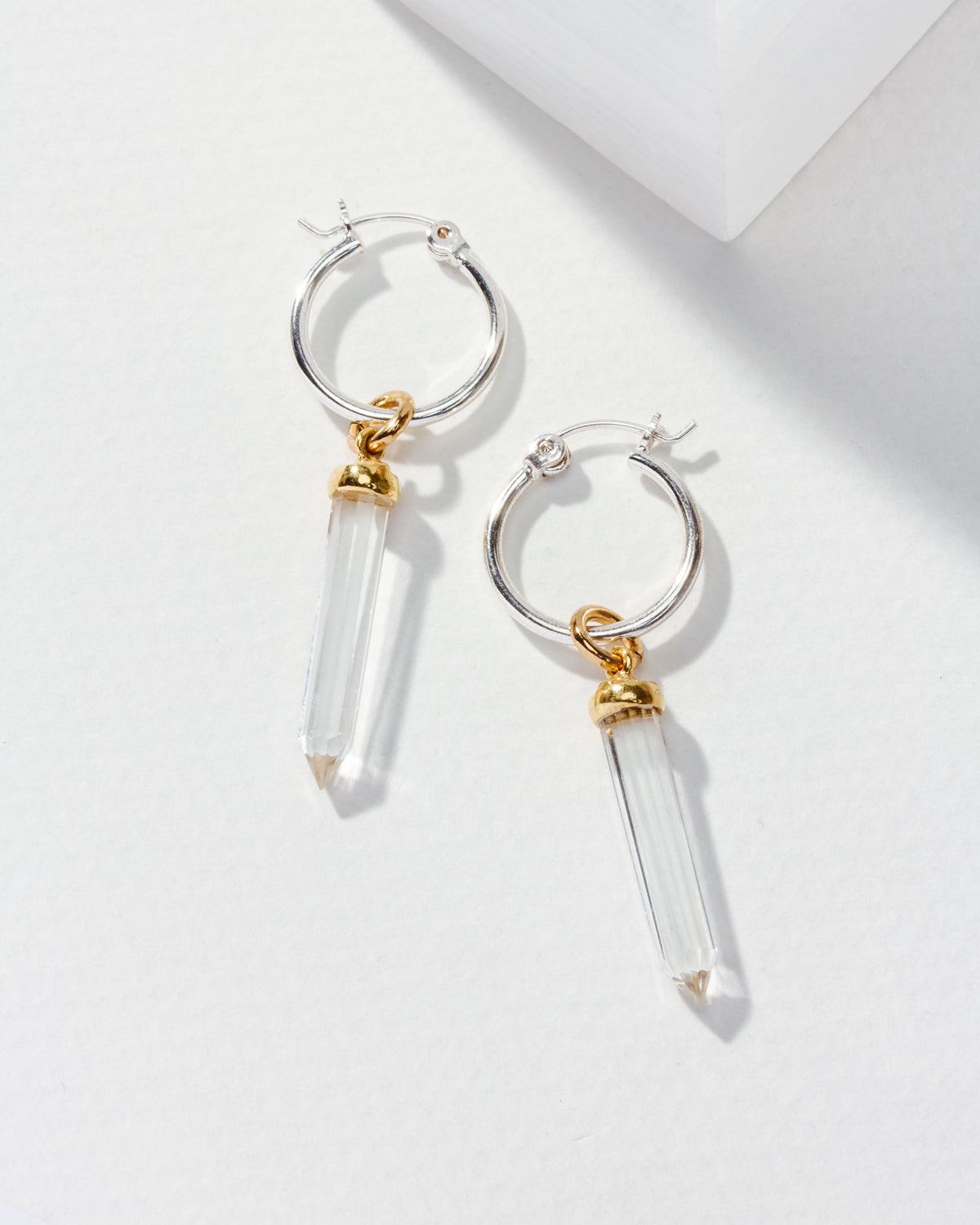 Pair of silver Rayanne Interchangeable Hoops with clear crystal pendants and gold accents are