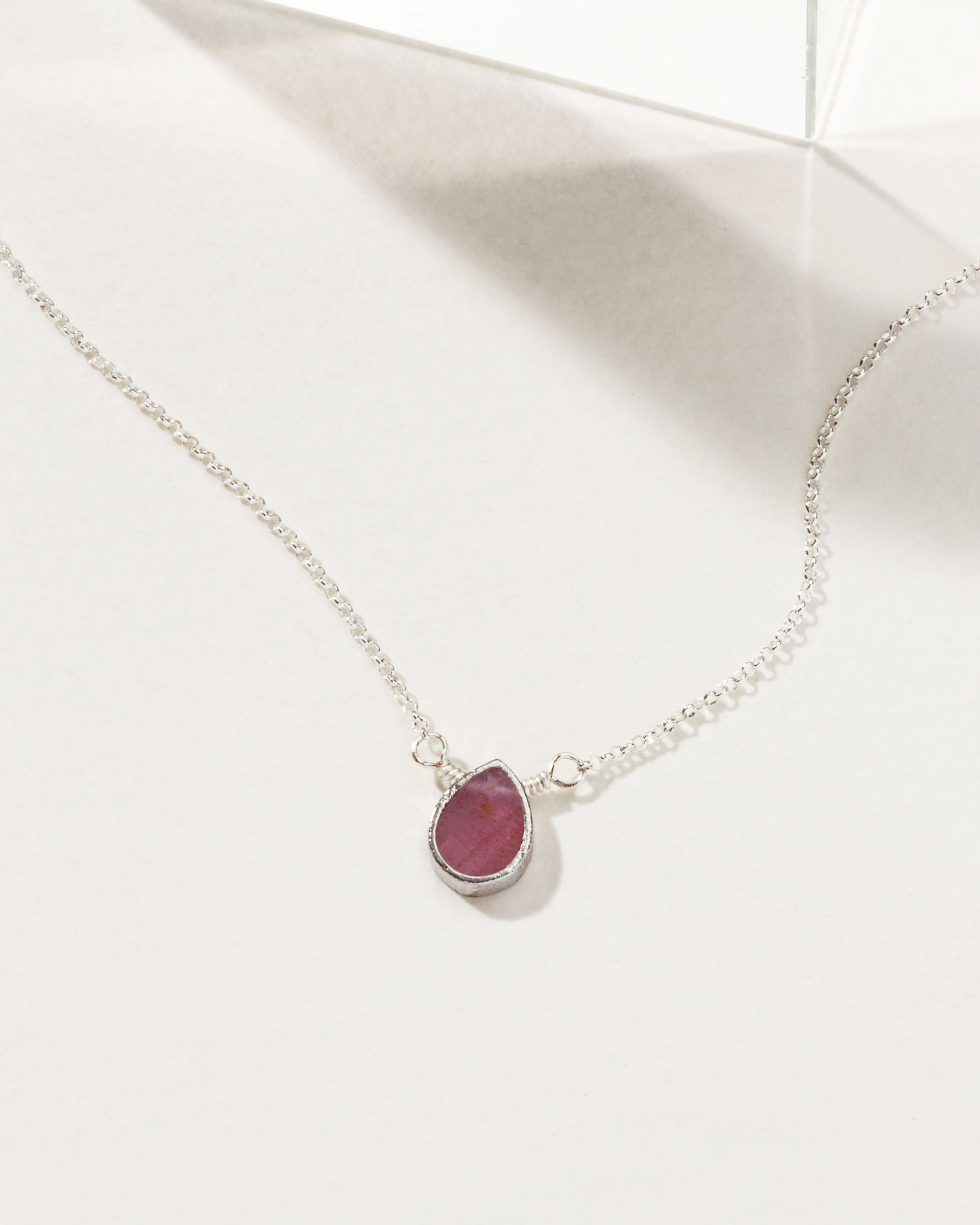 Silver plated brass necklace with a teardrop ruby gemstone pendant.
