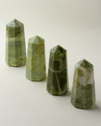 Four Serpentine Towers, each a slightly different shade of green, stand in a row.