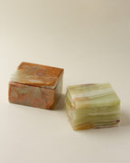 Two calcite jewelry boxes: one brown and one green.