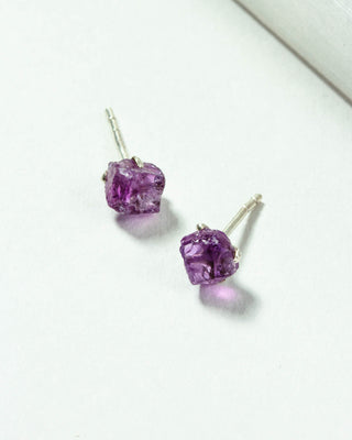 Amethyst Raw Beauty Birthstone Post Earrings on a white tabletop