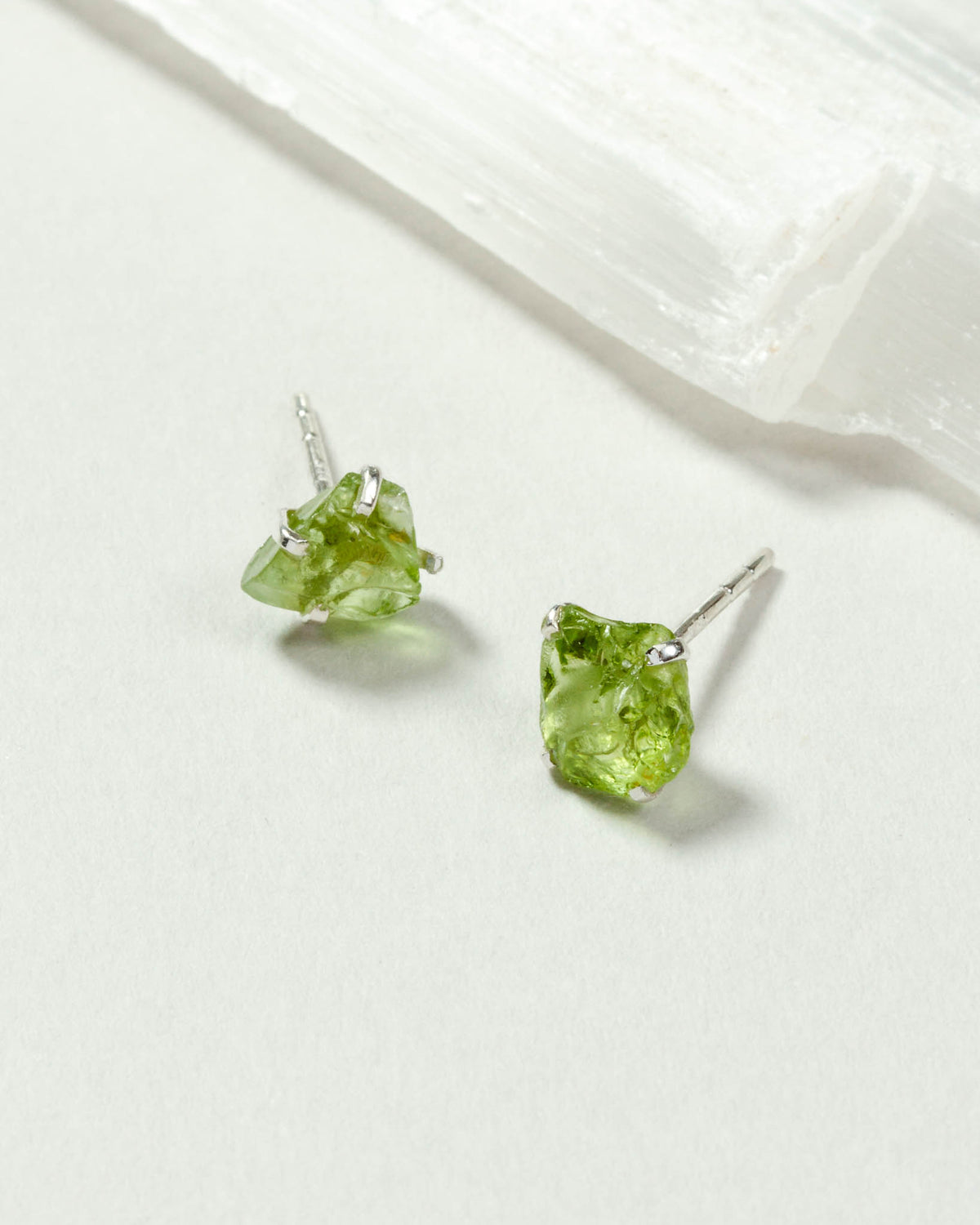 Peridot Raw Beauty Birthstone Post Earrings on a white tabletop
