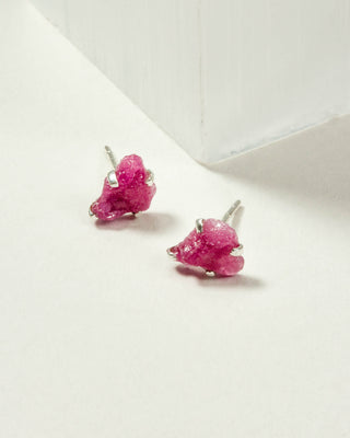 Ruby Raw Beauty Birthstone Post Earrings on a white tabletop