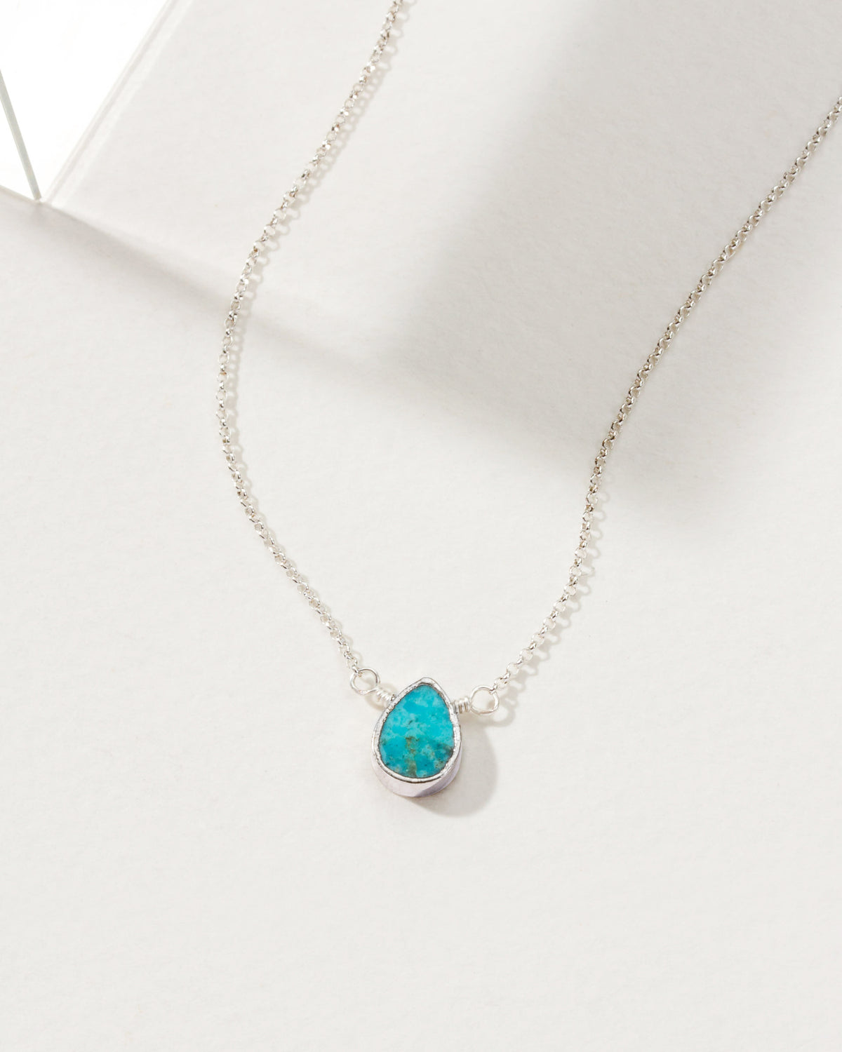 Necklace with a turquoise gemstone pendant and silver plated brass chain.
