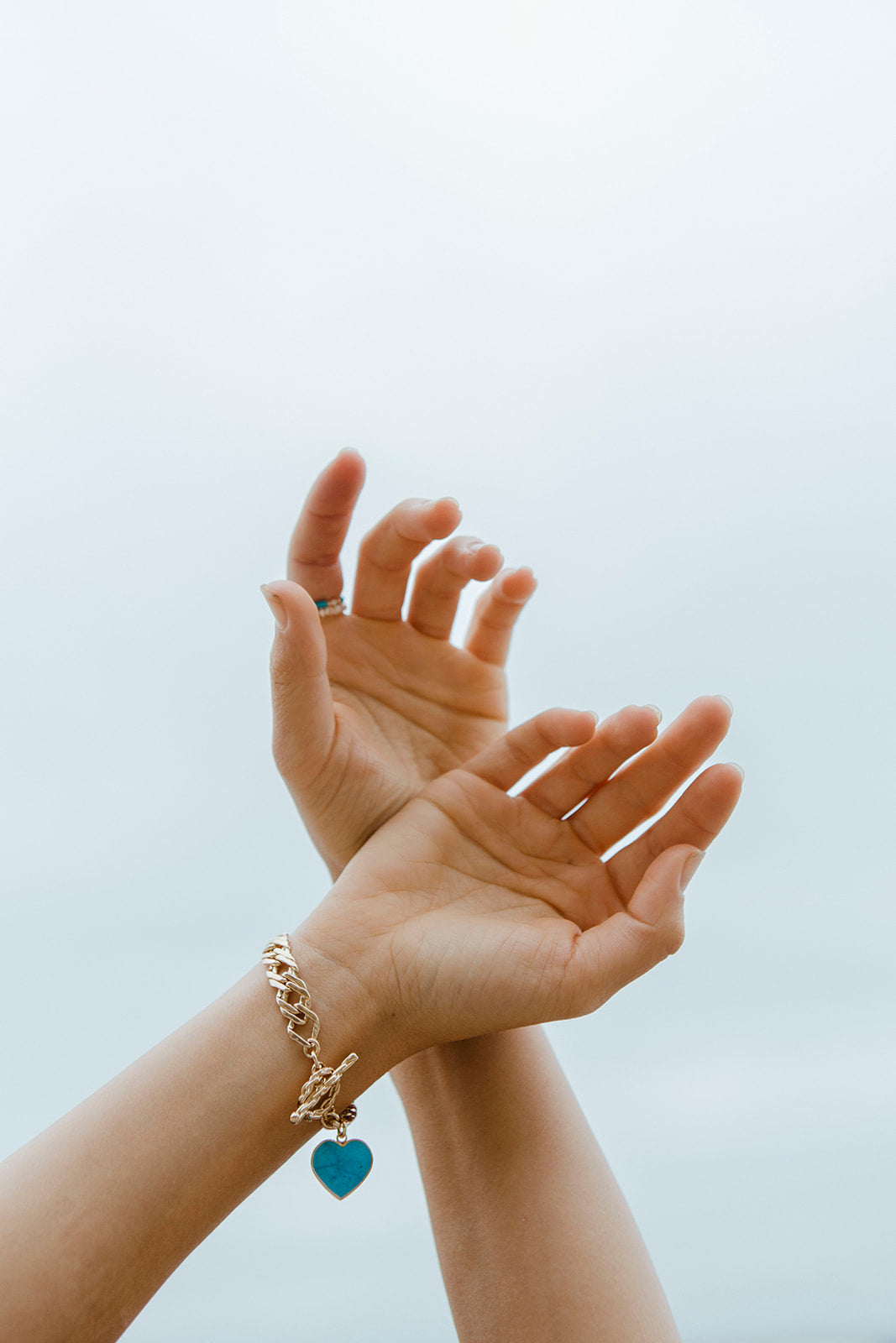 Heart of Gold Toggle bracelet with a Turquoise Howlite heart charm on a hand.