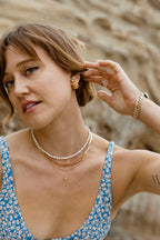 Orb Front Back Earring Gold: A woman wears gold orb earrings with a high-polish finish.