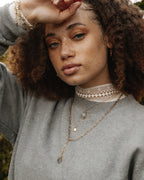 Model wears a Wild Thing necklace with 14KT Gold Plated Brass, and a clear crystal.