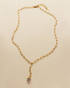 Gold chain necklace with a pale purple gemstone pendant.