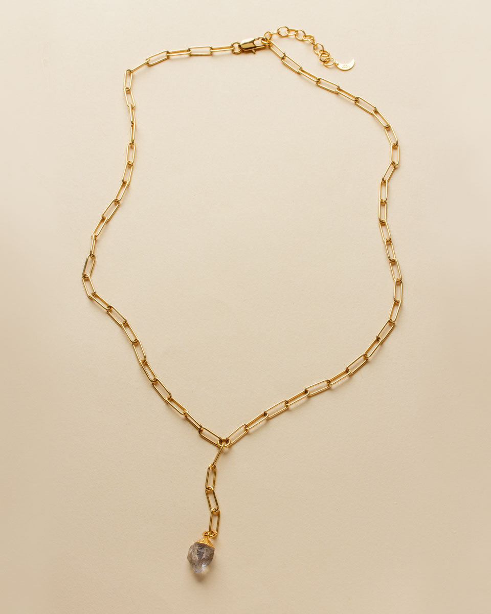 Gold chain necklace with a pale purple gemstone pendant.