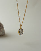 Gold chain necklace featuring tourmalinated quartz pendant.